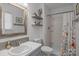 Bright bathroom featuring a tub/shower, neutral walls, floating shelves, and a wood-trimmed mirror over the sink at 6325 Yount Dr, Salisbury, NC 28147