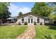Charming single-story home with a stone walkway leading to a cozy outdoor patio area, all surrounded by lush greenery at 6325 Yount Dr, Salisbury, NC 28147