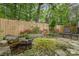 Private backyard with a stone water feature, lush plantings and mature trees at 652 Camrose Ne Cir, Concord, NC 28025