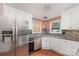 Open kitchen with stainless steel appliances, granite countertops, and warm hardwood floors at 652 Camrose Ne Cir, Concord, NC 28025