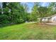This backyard features a lush lawn, privacy fence, storage shed, and mature trees at 6558 Covecreek Dr, Charlotte, NC 28215