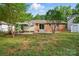 This backyard has a brick house, a covered patio, and mature trees at 6558 Covecreek Dr, Charlotte, NC 28215
