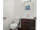 Bathroom with white sink, mirror, toilet, and white walls at 6558 Covecreek Dr, Charlotte, NC 28215