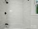 Bathroom featuring tiled walls, bathtub, and window view at 6558 Covecreek Dr, Charlotte, NC 28215