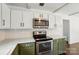 White subway tile backsplash, stainless appliances and white cabinets in a well-lit kitchen at 6558 Covecreek Dr, Charlotte, NC 28215
