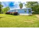 Charming single-story home with lush landscaping and mature trees on a sunny day at 7041 Kays Dr, York, SC 29745
