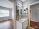 Well-lit bathroom with granite vanity, framed mirror, and hardwood flooring at 7642 Horseshoe Creek Dr, Huntersville, NC 28078