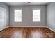 Spacious bedroom with hardwood floors and two windows providing natural light at 7642 Horseshoe Creek Dr, Huntersville, NC 28078
