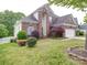 Beautiful two-story brick home featuring a manicured lawn, well-placed shrubbery and an attached garage at 7642 Horseshoe Creek Dr, Huntersville, NC 28078