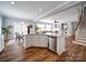 Open-concept kitchen with granite counters, stainless appliances, and an island with bar seating overlooking the living room at 7642 Horseshoe Creek Dr, Huntersville, NC 28078