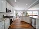 Bright kitchen features an island with bar seating, stainless appliances, granite countertops, and an open floor plan at 7642 Horseshoe Creek Dr, Huntersville, NC 28078