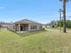 A spacious backyard showcasing a well-maintained lawn and the home's exterior with gray siding at 7642 Porrera St, Charlotte, NC 28214