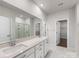 Bathroom featuring double vanity, quartz countertops, large mirror, and a tiled walk-in shower at 7642 Porrera St, Charlotte, NC 28214