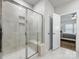 Walk-in shower with glass door and built-in bench in bathroom, with view into main bedroom at 7642 Porrera St, Charlotte, NC 28214