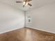 Simple yet spacious bedroom with hardwood floors, a ceiling fan, and a window for natural light at 7642 Porrera St, Charlotte, NC 28214