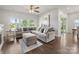 Spacious living room featuring a large sectional sofa, ceiling fan, and natural light from the windows at 7642 Porrera St, Charlotte, NC 28214