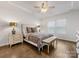 Main bedroom suite features a ceiling fan, hardwood floors, bedside tables, and a cozy bench at 7642 Porrera St, Charlotte, NC 28214