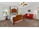 Well-lit bedroom features a wood frame bed, neutral carpet, and comfortable seating at 79044 Ridgehaven Rd, Lancaster, SC 29720
