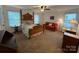 Spacious bedroom featuring a four-poster bed, a ceiling fan, and a cozy sitting area with a red sofa at 79044 Ridgehaven Rd, Lancaster, SC 29720
