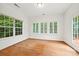 Light-filled sunroom with hardwood floors and multiple windows offering serene outdoor views at 8120 Calistoga Ln, Waxhaw, NC 28173