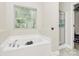 Bright bathroom featuring a soaking tub, separate shower, and large window for natural light at 8200 Park Vista Cir, Charlotte, NC 28226