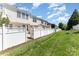 View of white fenced backyard in a well maintained townhouse community with blue skies at 827 Gentlewinds Ct, Fort Mill, SC 29708