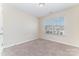 A cozy bedroom with neutral walls, carpet flooring and a large window providing natural light at 827 Gentlewinds Ct, Fort Mill, SC 29708