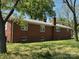 Brick home exterior featuring multiple chimneys and several windows at 8588 Smith Rd, Kannapolis, NC 28081