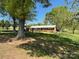 Brick ranch style home with mature trees and landscaping under a blue sky at 8588 Smith Rd, Kannapolis, NC 28081