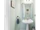 Powder room with pedestal sink, light green walls, and decorative mirror at 8814 Gerren Ct, Charlotte, NC 28217