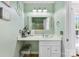 Well-lit bathroom vanity featuring a square mirror, white cabinets, and updated fixtures against calming seafoam green walls at 8814 Gerren Ct, Charlotte, NC 28217