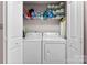 Convenient laundry closet with washer, dryer, and shelving for ample storage of cleaning supplies and paper towels at 8814 Gerren Ct, Charlotte, NC 28217