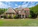 Beautiful brick two-story home with a well-manicured lawn and lovely landscaping at 900 Springwood Dr, Waxhaw, NC 28173