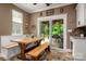 Charming breakfast nook with custom bench seating, wooden table and sliding glass door to outdoor area at 900 Springwood Dr, Waxhaw, NC 28173