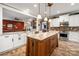 Open kitchen boasts white cabinets, stainless steel appliances, and a granite-topped island overlooking the living area at 900 Springwood Dr, Waxhaw, NC 28173