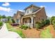 Beautiful brick home featuring a cozy front porch, stone accents, and lush landscaping in a serene setting at 9319 Highclere Ct, Matthews, NC 28105