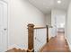 Open hallway featuring hardwood floors, wood railing, and view to bedroom at 9319 Highclere Ct, Matthews, NC 28105