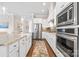 Modern kitchen featuring stainless steel appliances, white cabinets, and a patterned runner at 9319 Highclere Ct, Matthews, NC 28105