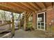 Backyard patio with stairs to the upper deck, a screened door, and brick wall, offering a cozy outdoor space at 118 Taylor Ct # 16, Mooresville, NC 28117