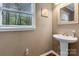 Charming powder room features a pedestal sink, wood floors, and ample natural light at 118 Taylor Ct # 16, Mooresville, NC 28117