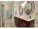 This bathroom features double sinks, a wooden vanity, and large mirrors to get ready for the day at 118 Taylor Ct # 16, Mooresville, NC 28117