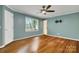 This primary bedroom features gleaming hardwood floors, a ceiling fan and natural light from the large window at 118 Taylor Ct # 16, Mooresville, NC 28117