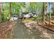 Home with detached garage and gravel driveway surrounded by tall mature trees at 118 Taylor Ct # 16, Mooresville, NC 28117