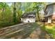 Exterior shot of a three-car garage with a driveway, situated beside a house surrounded by lush greenery at 118 Taylor Ct # 16, Mooresville, NC 28117