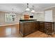 Open-concept kitchen features a breakfast bar with dark wood cabinets and stylish pendant lighting at 118 Taylor Ct # 16, Mooresville, NC 28117