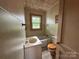 Compact bathroom featuring a sink, tub, and toilet with window for natural light at 135 Hendren Ln, Hiddenite, NC 28636
