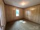 Cozy bedroom with wood paneled walls, carpet flooring, and a sun-filled window at 135 Hendren Ln, Hiddenite, NC 28636