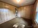 Comfortable bedroom with wood paneled walls, carpet flooring, and two entry doors at 135 Hendren Ln, Hiddenite, NC 28636