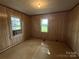 A bedroom with wood paneled walls and two windows with an air conditioner to help you keep cool at 135 Hendren Ln, Hiddenite, NC 28636