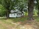 Quaint single-story home nestled among mature trees, featuring a spacious yard and front access ramp at 135 Hendren Ln, Hiddenite, NC 28636
